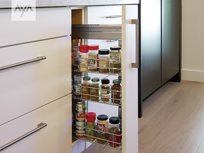 Narrow pull-out spice drawer with spices in the top row and oils below