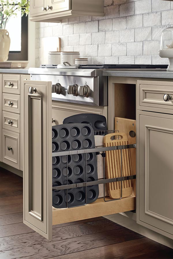 Narrow pull-out drawer containing sheet pans and muffin trays standing on their sides.